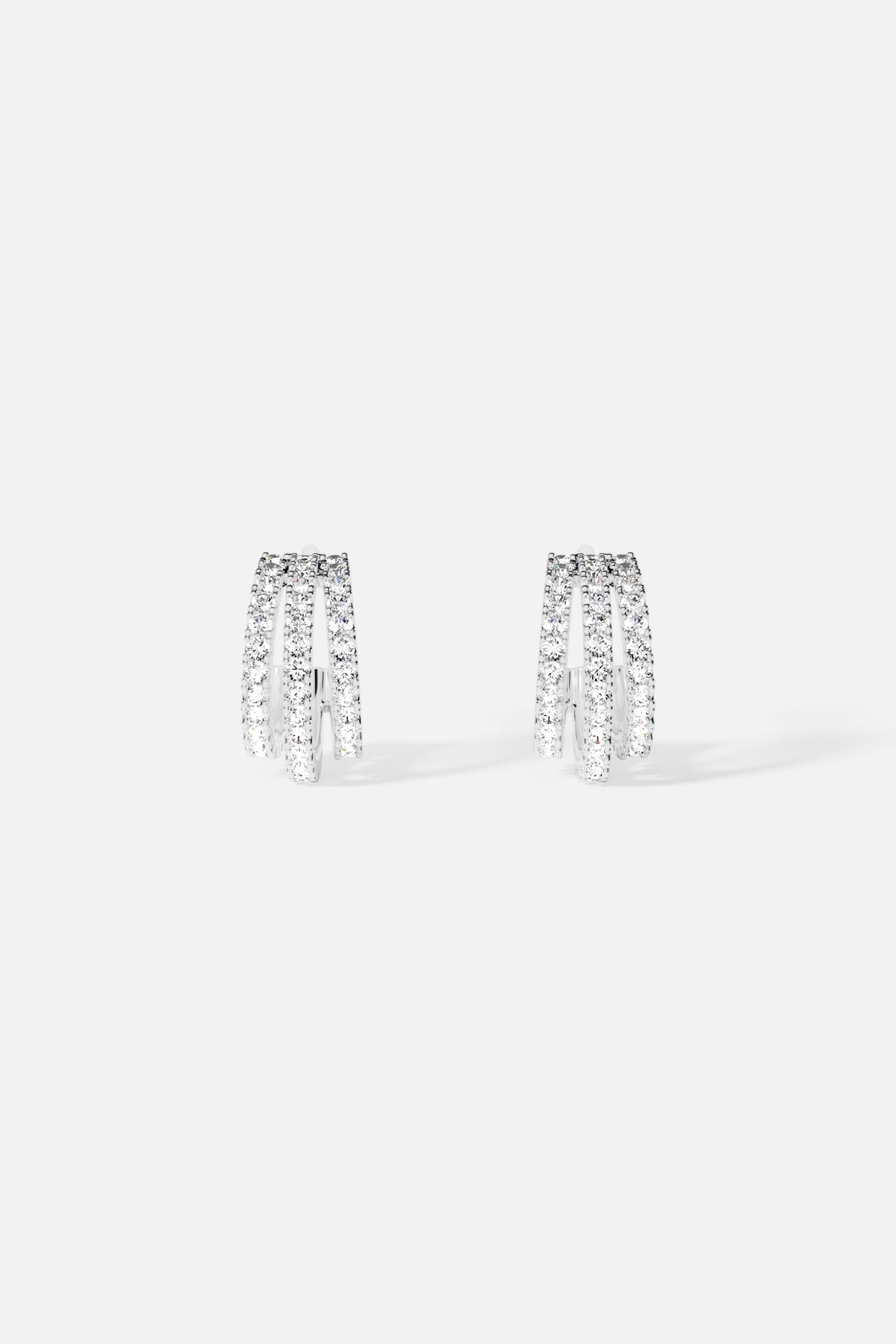 APM Earrings, triple arcs of shimmer in a rhodium finish, quietly radiant.