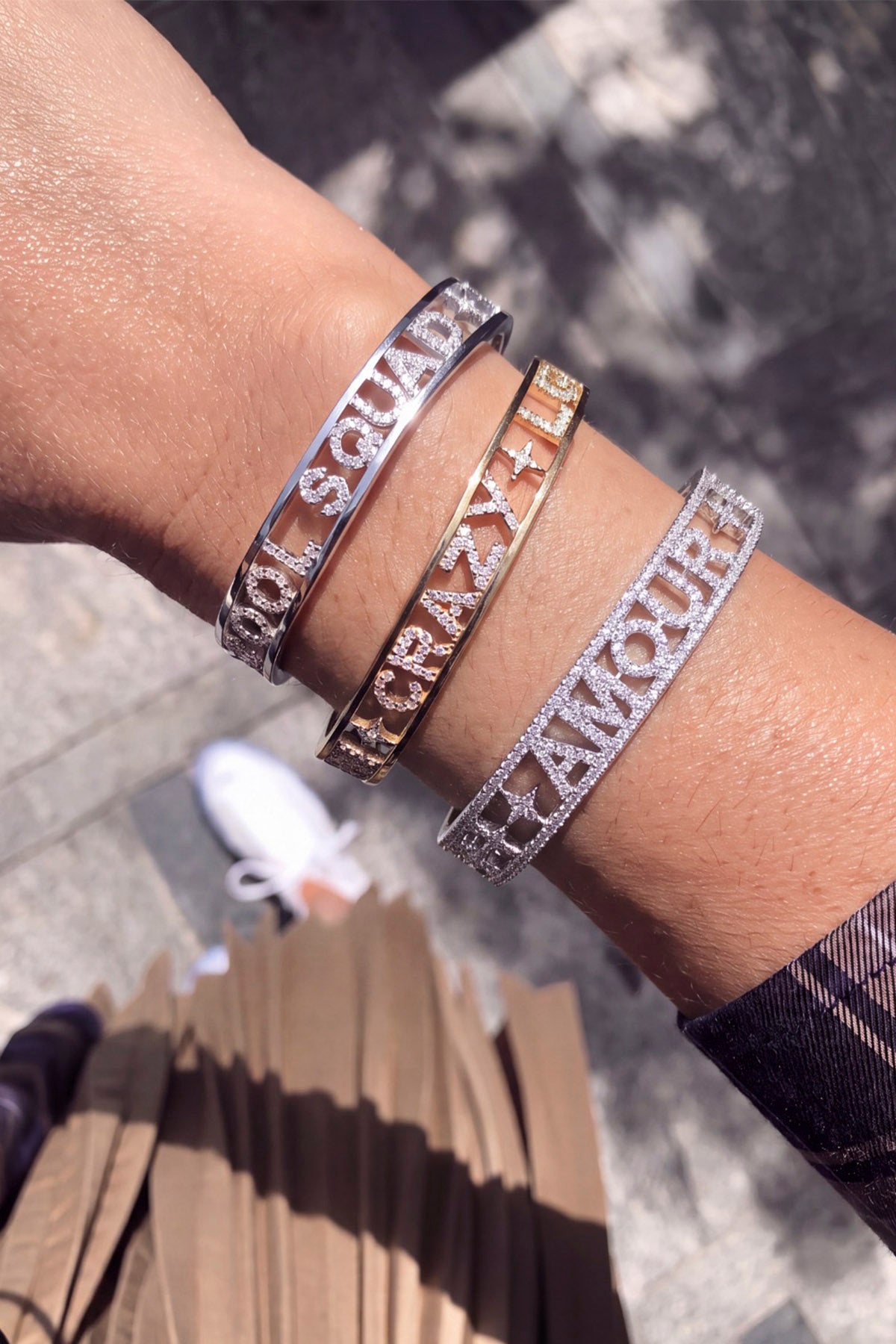Woman wearing APM Monaco bangles, a sparkling stack of playful statements under the sun.