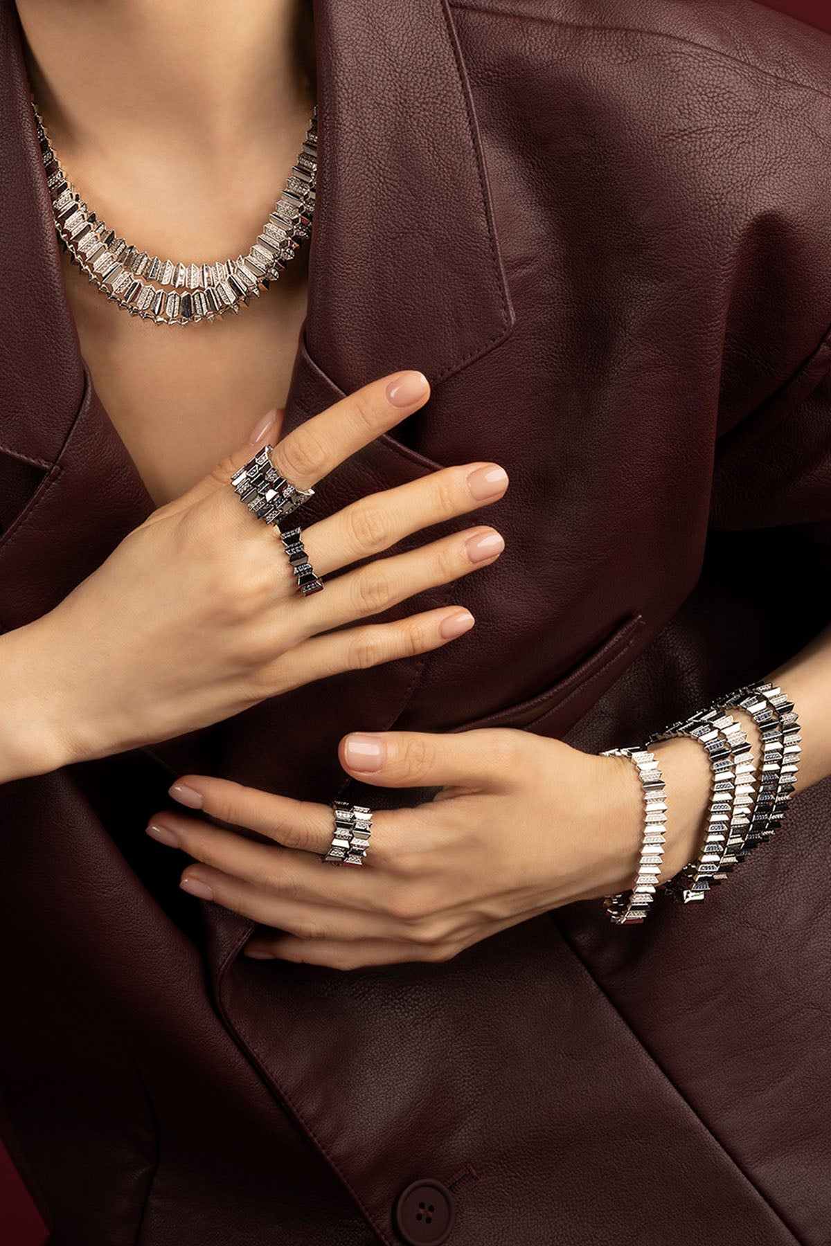 Woman wearing APM Morse jewelry set, bold rhodium finish meets quiet after-dark allure.