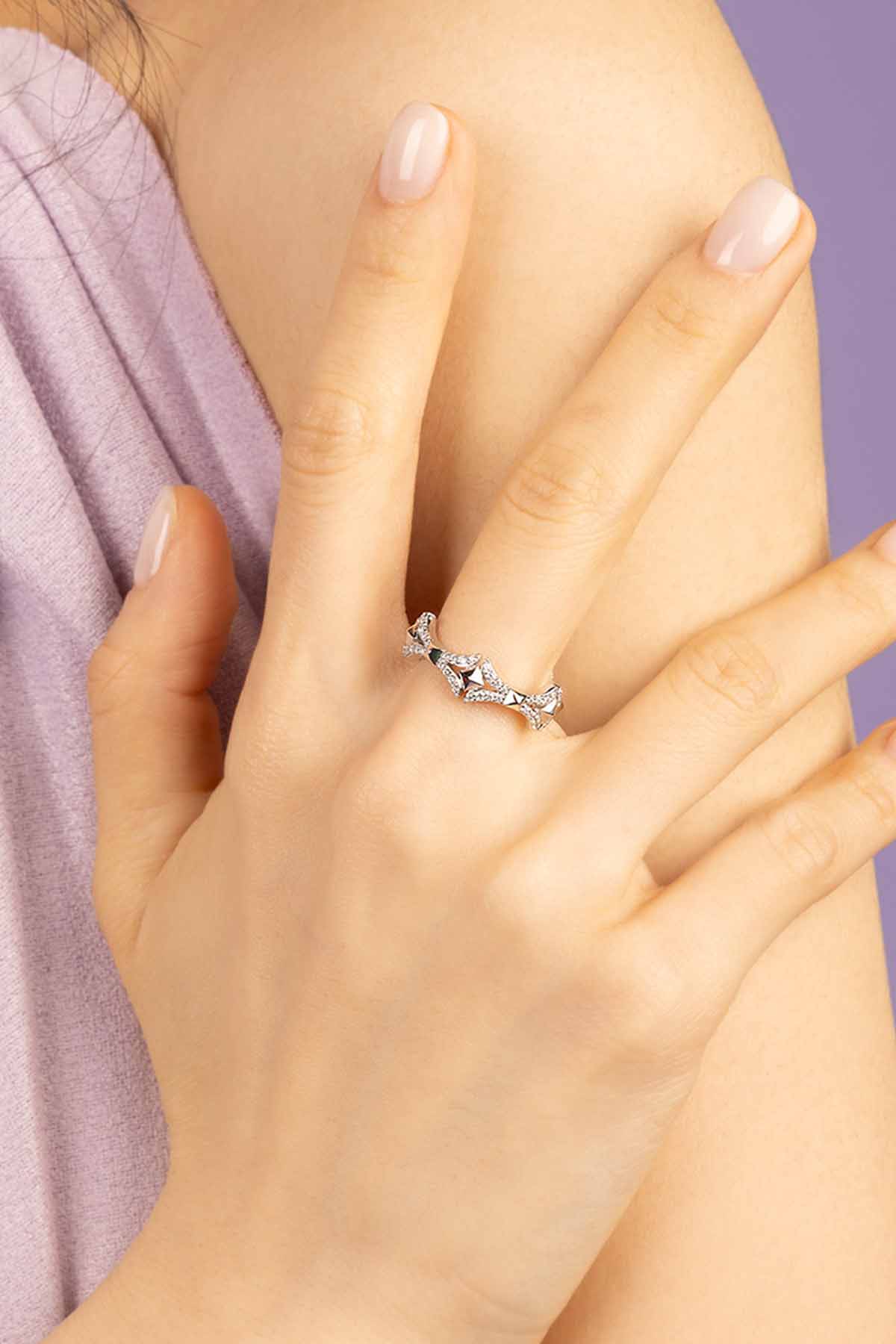 Silver-tone ring on a hand with a soft focus background