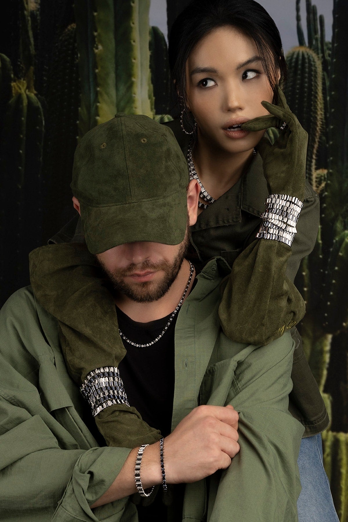 Two models in green jackets with cacti in the background