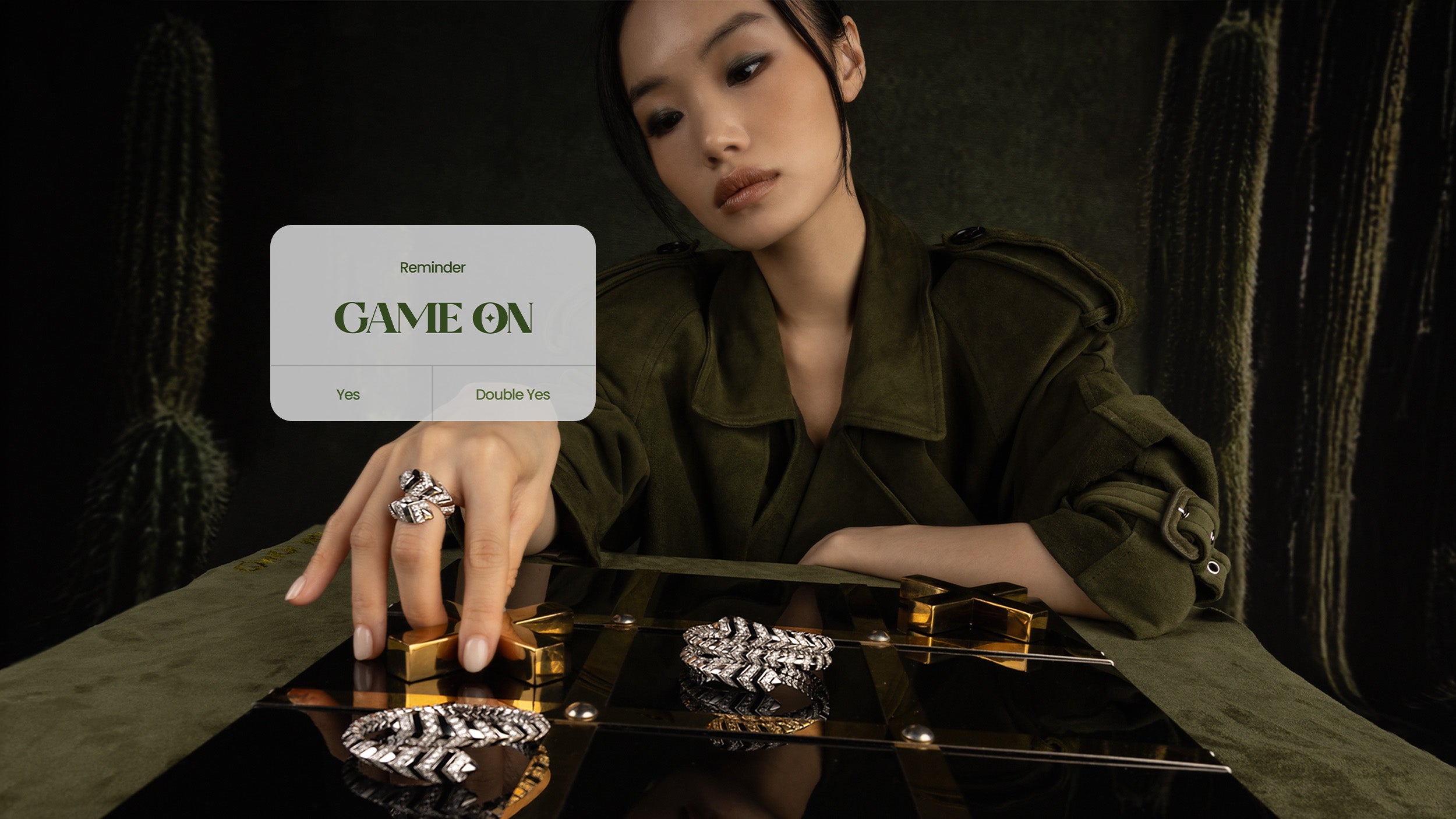 Woman holding APM MONACO KAA jewelry with a 'Game On' card in the background