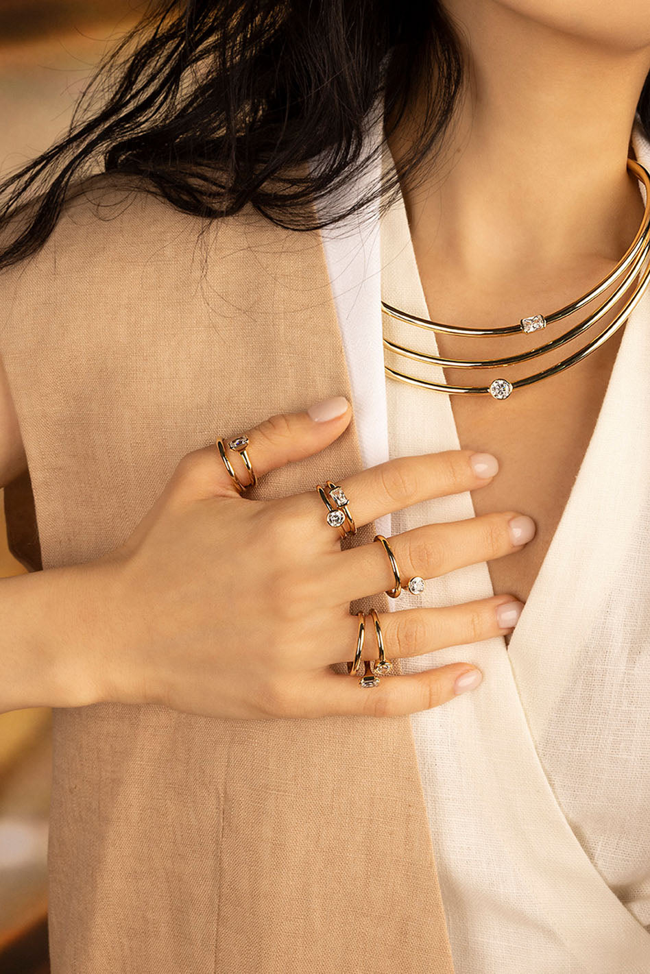 Rings APM Monaco, yellow gold twist pavé ring with white stones worn on the finger.