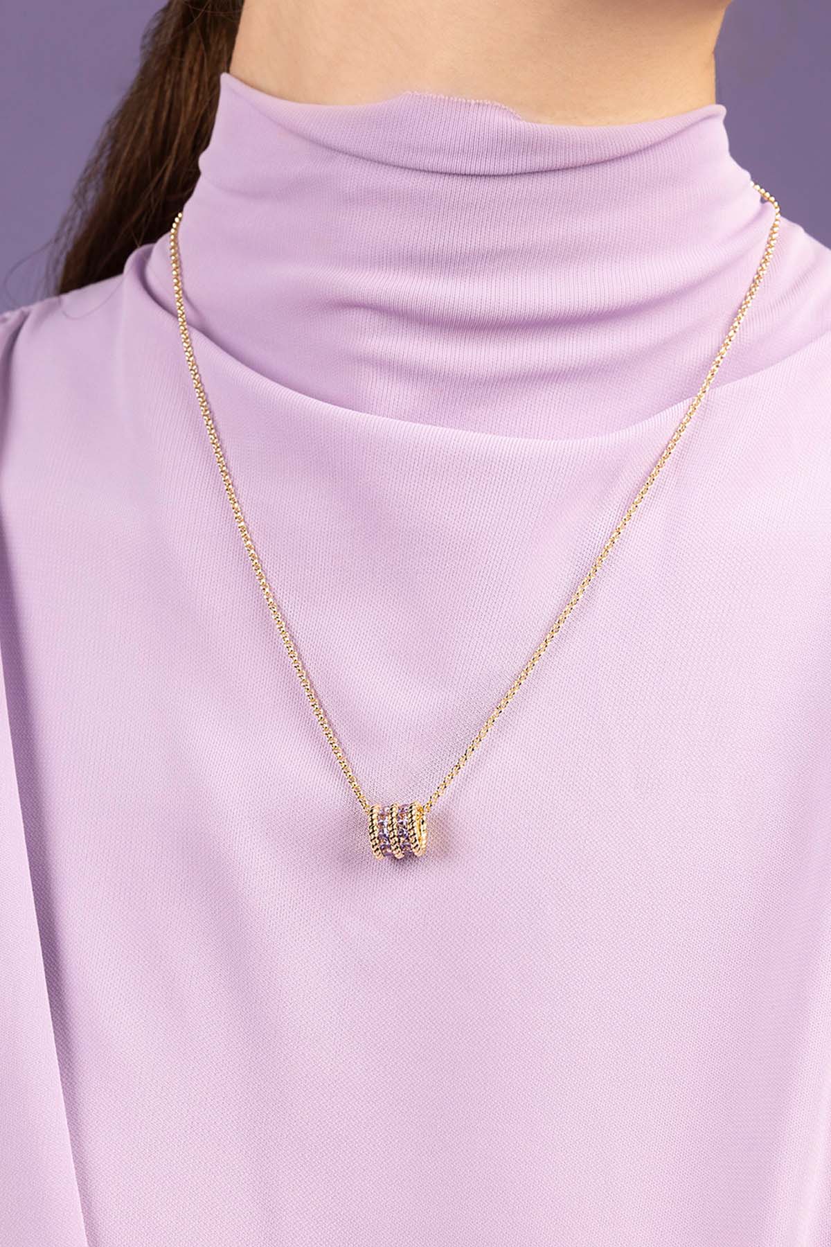 APM MONACO lilac torsade adjustable necklace in yellow gold worn on model with purple top