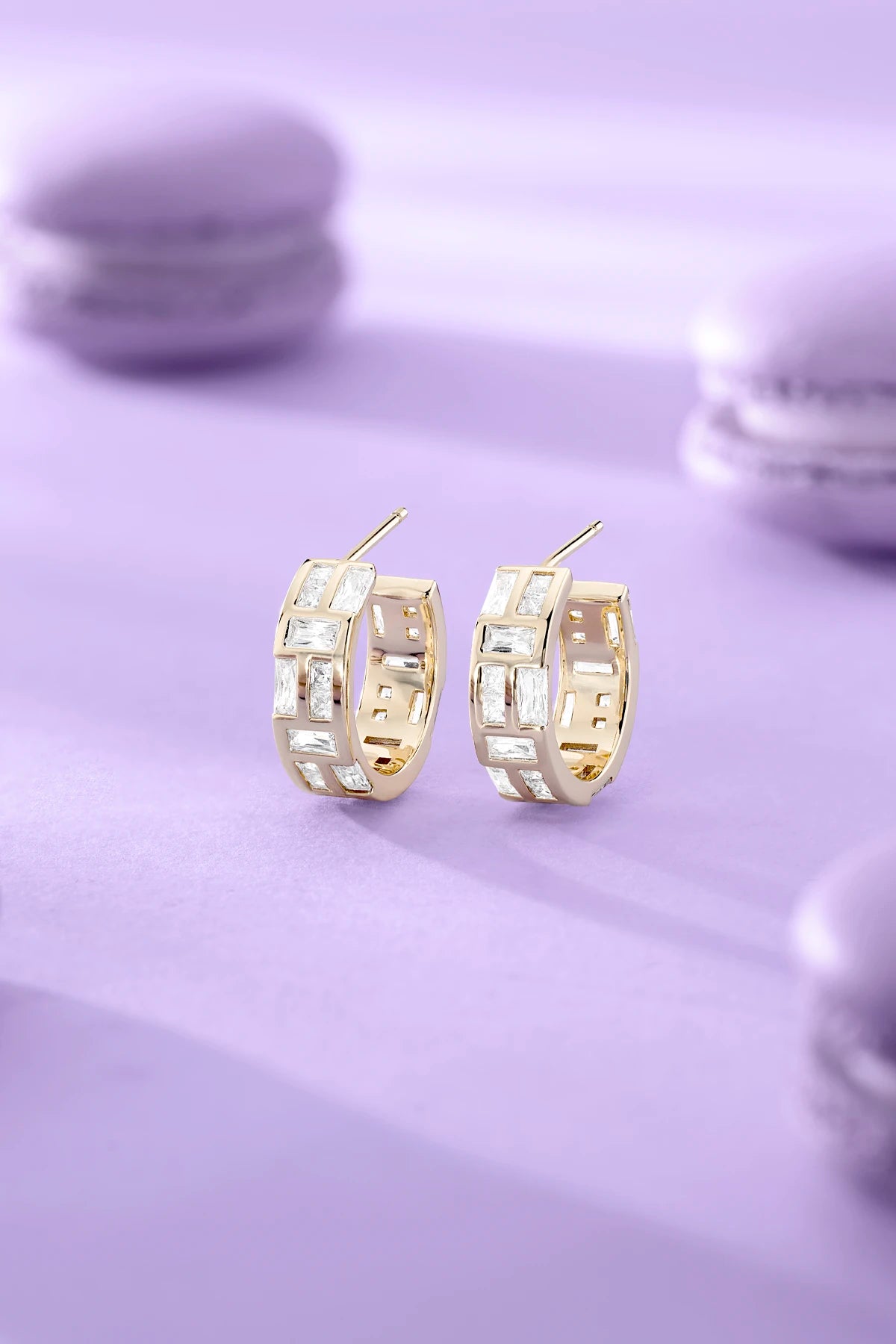 APM MONACO yellow gold earrings on purple background