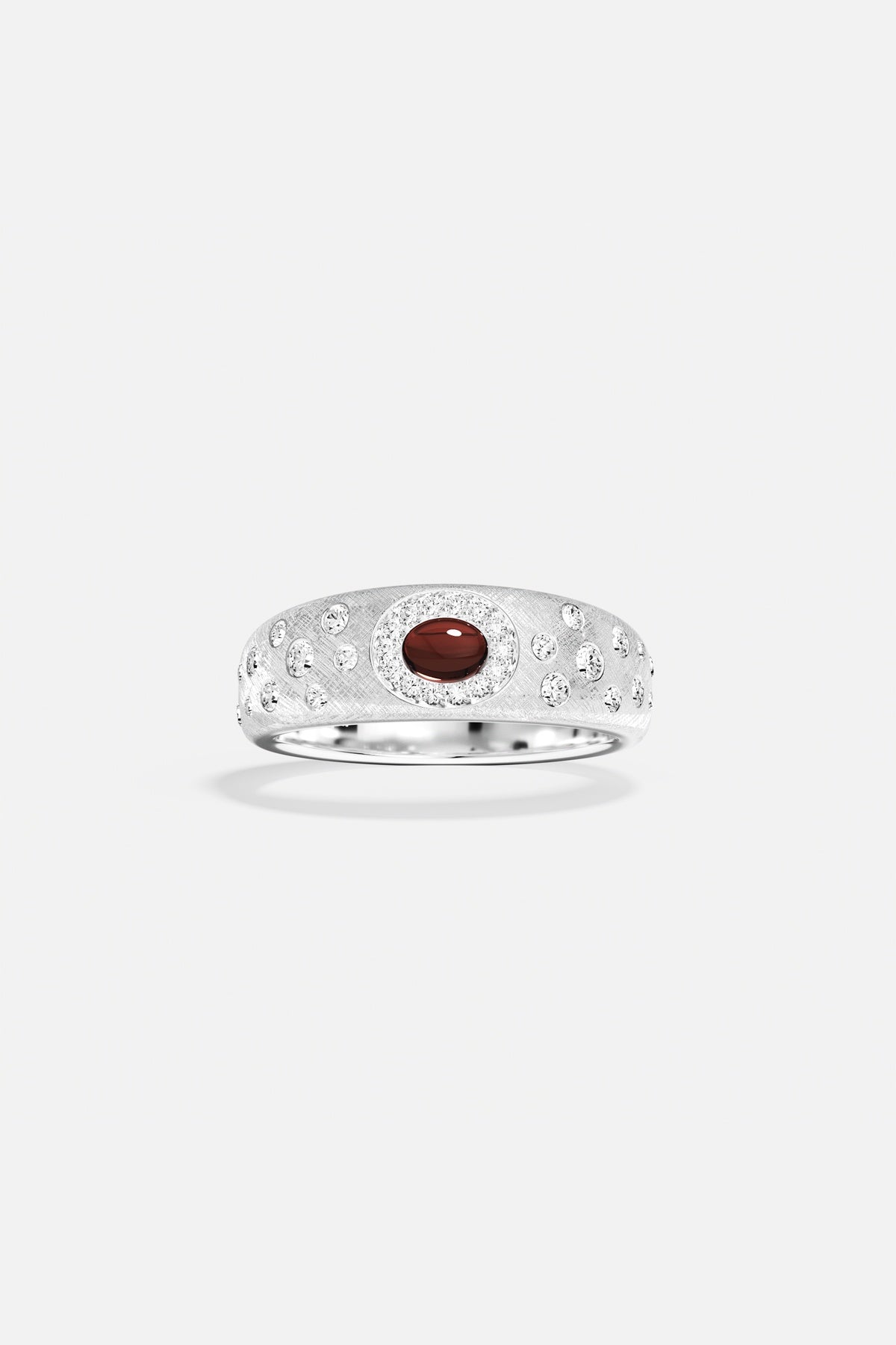 APM Ring in rhodium finish, a deep red gem glowing with quiet elegance.