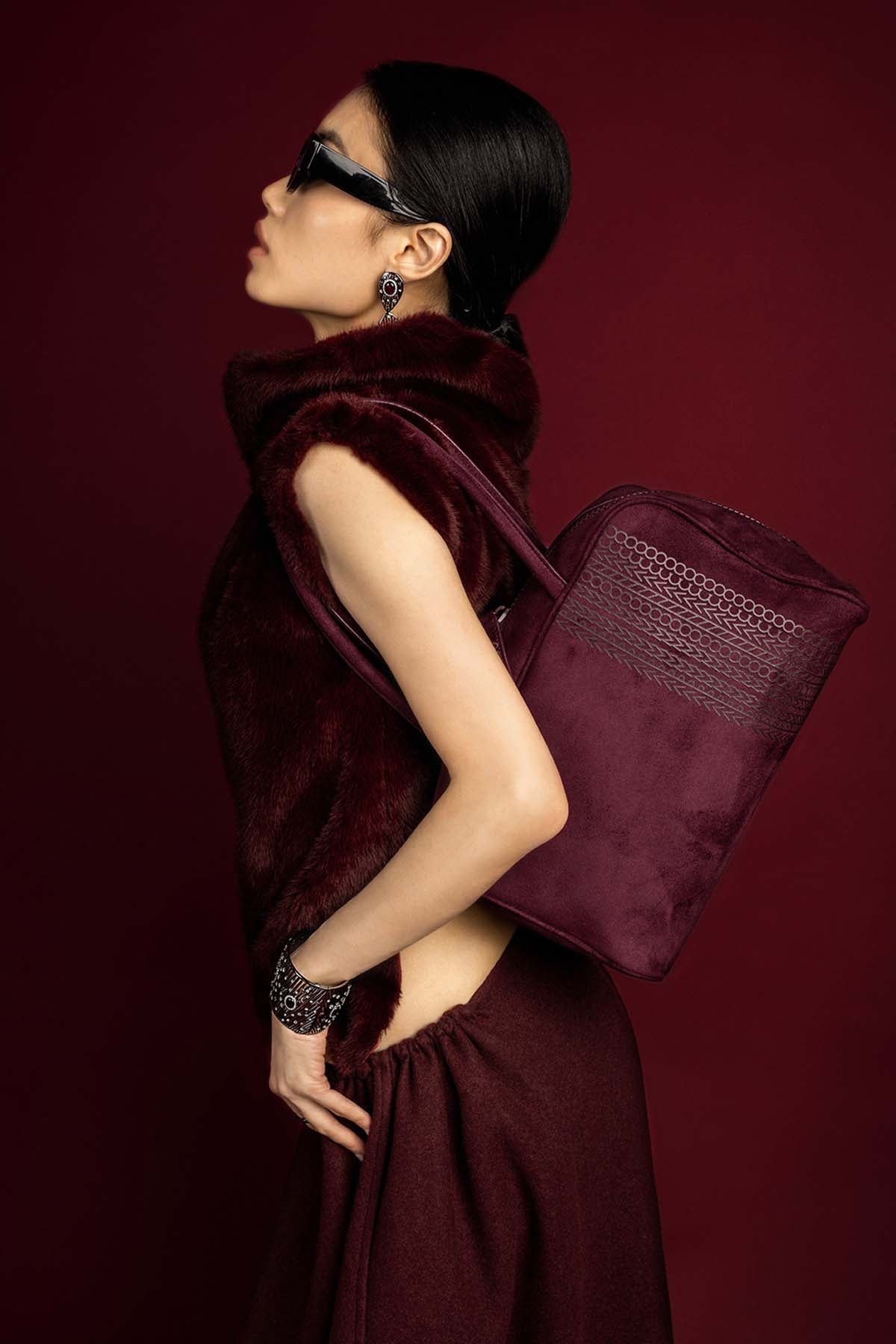 Woman wearing APM Monaco earrings and cuff, a bold burgundy statement in rhodium finish.