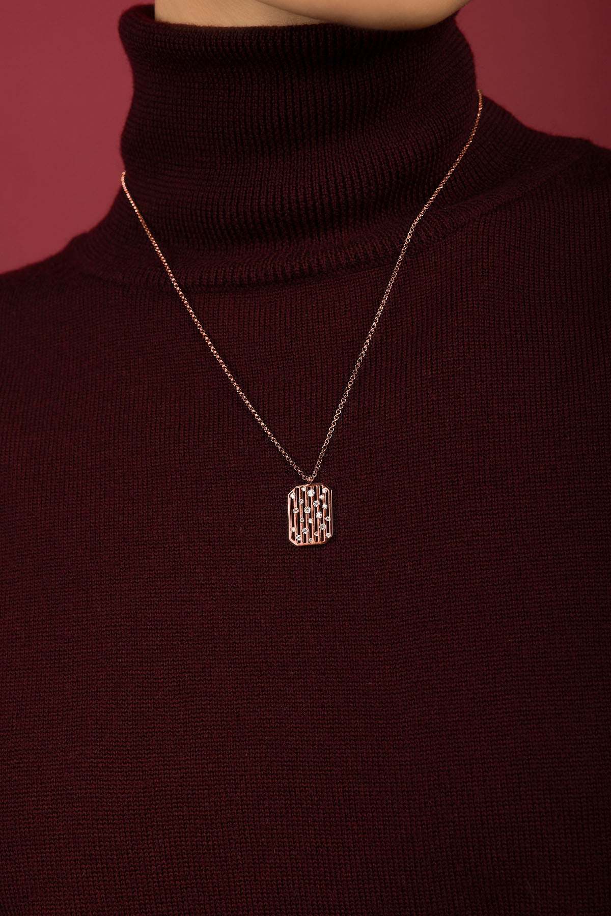 Woman wearing APM Necklace, a rose-hued whisper of modern elegance.