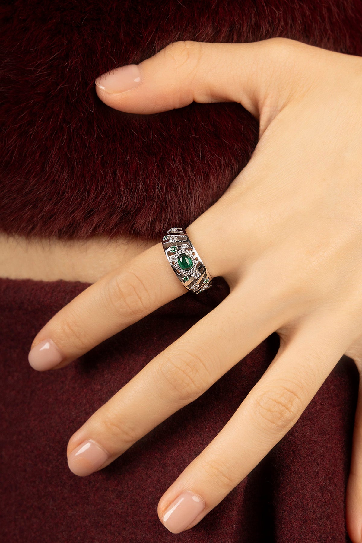 Woman wearing APM Ring, a green whisper of vintage elegance in rhodium finish.