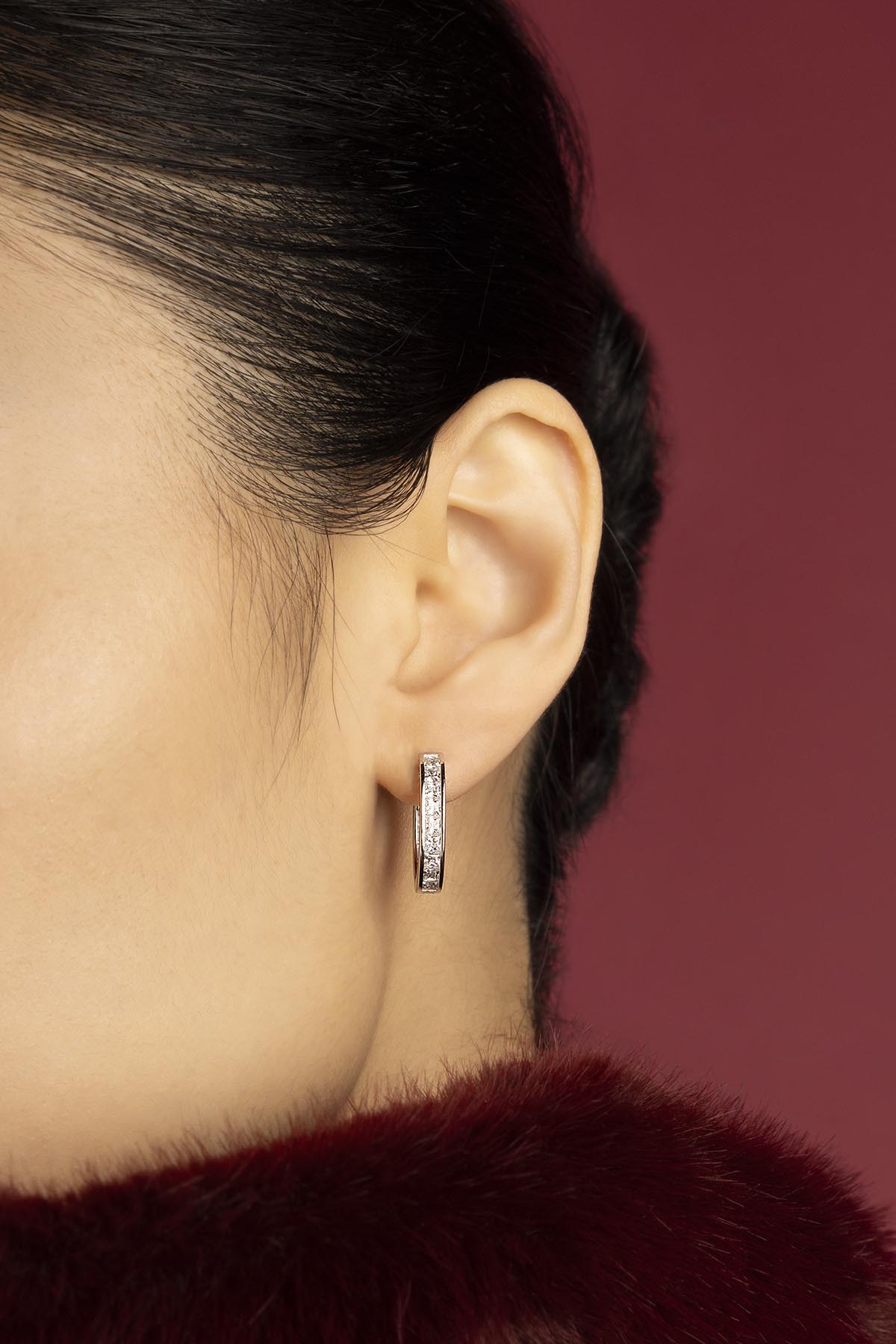 Woman wearing APM Monaco hoop earrings, a whisper of sparkle in rhodium finish.