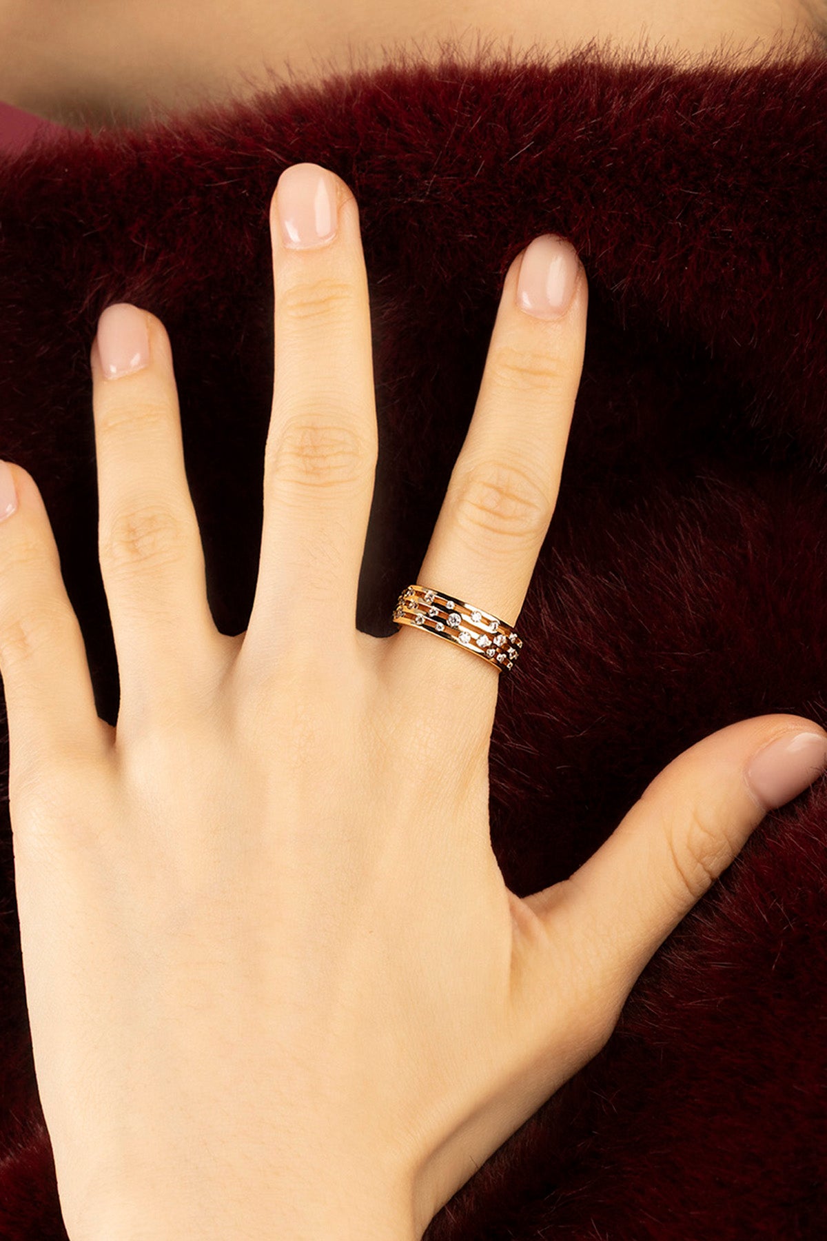 Woman wearing APM Ring, delicate rose glow scattered with sparkling stars.