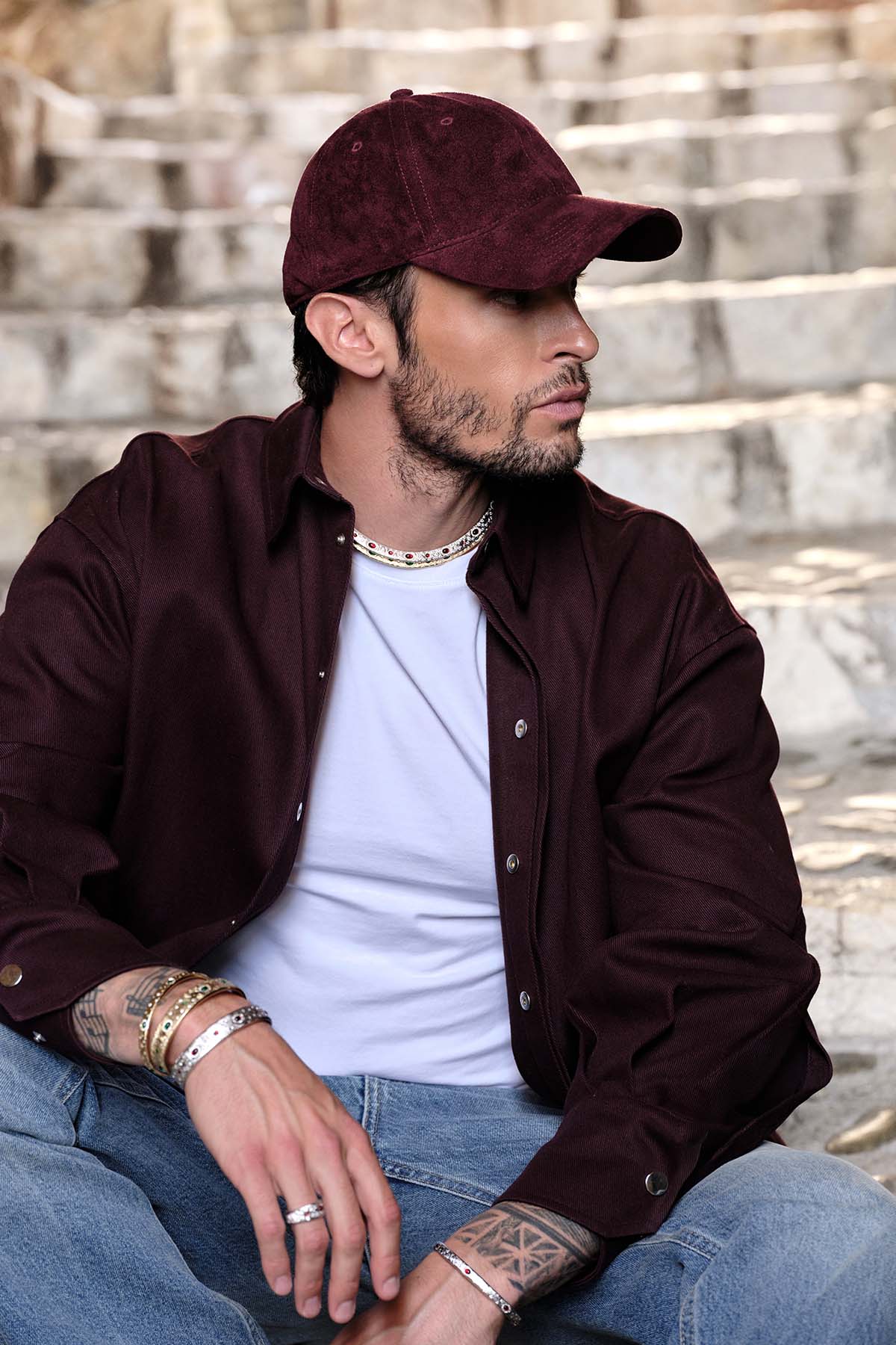 Man wearing APM Monaco layered bracelets and necklace, effortless urban charm.
