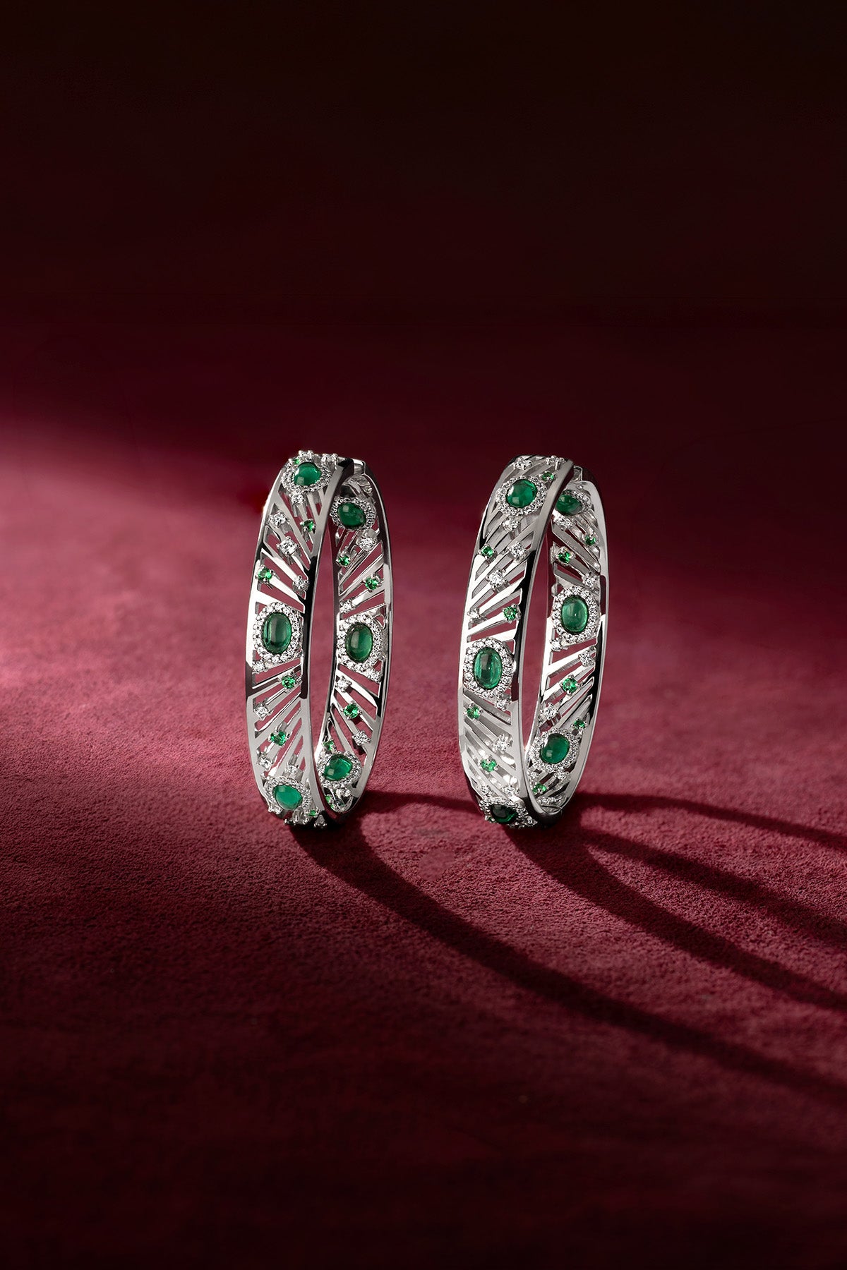 APM Bangles in rhodium finish, emerald green whispers of bold elegance.