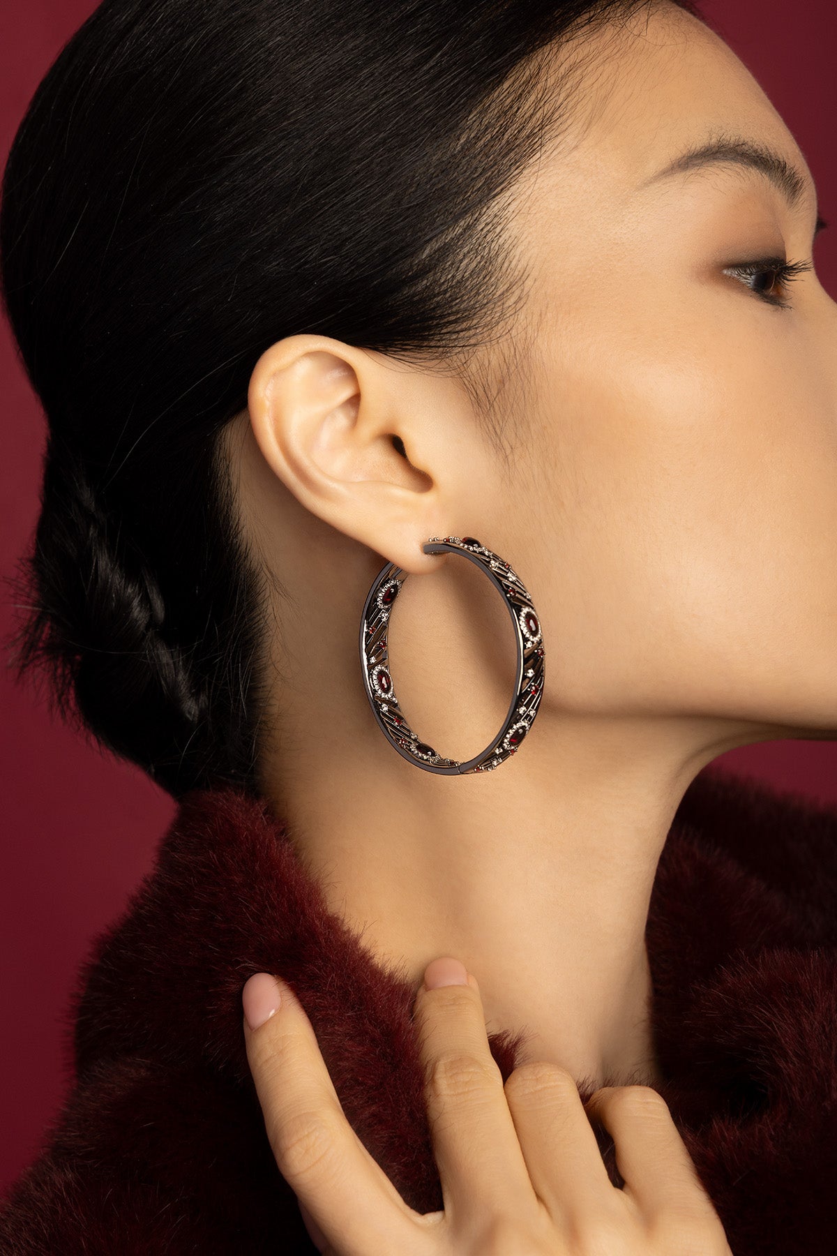 Woman wearing APM Hoop Earrings, bold elegance in deep ruby tones.