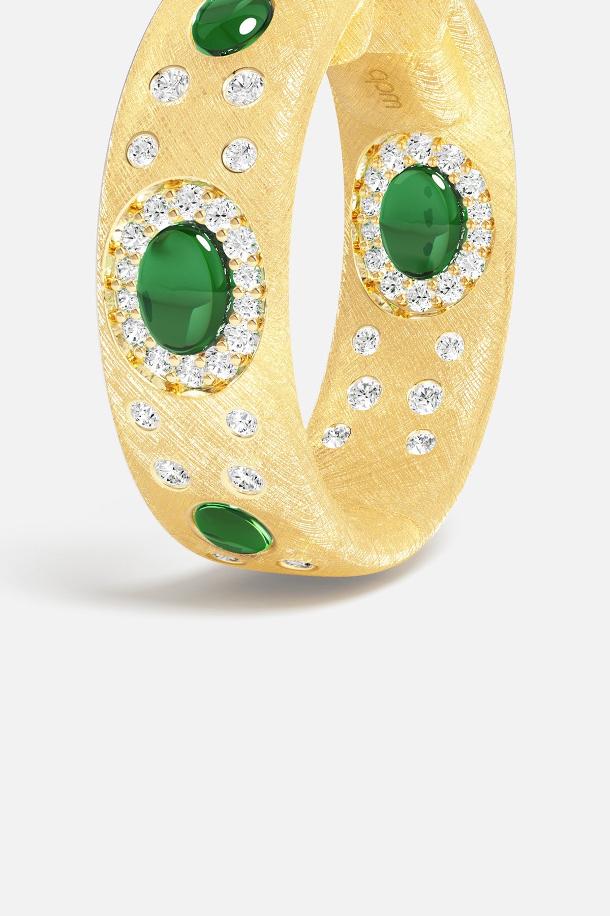 APM Ring in golden rhodium finish, green stones glowing like hidden treasures.