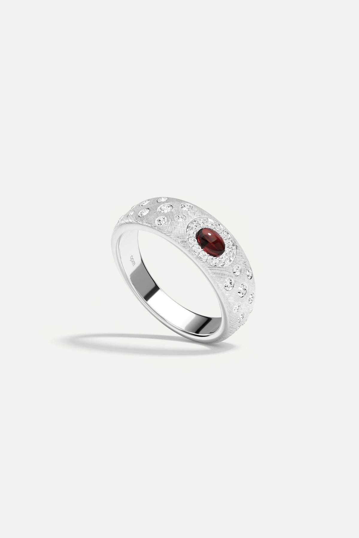 APM Ring in rhodium finish, a deep red glow whispering quiet elegance.