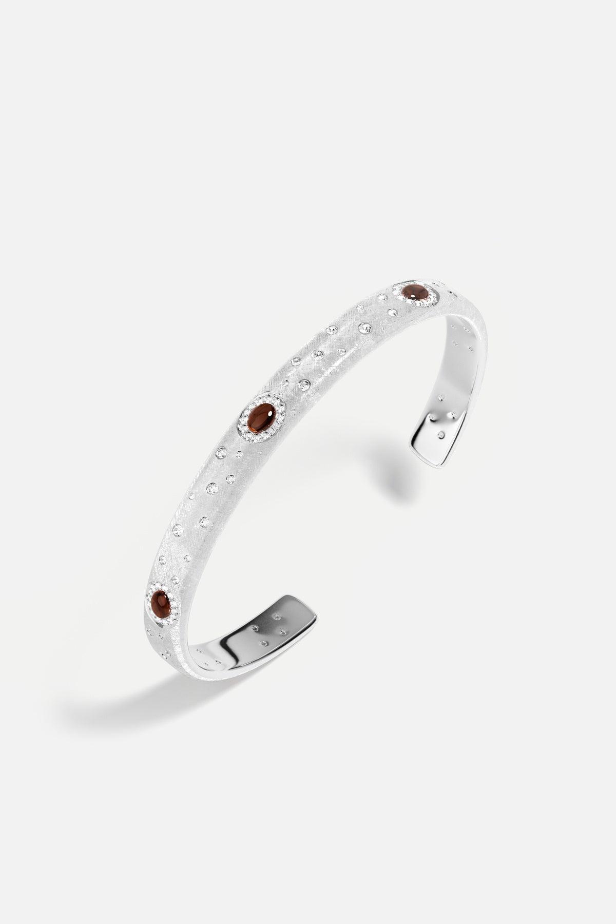 APM Monaco cuff bracelet in rhodium finish, scattered sparkles and deep amber accents.