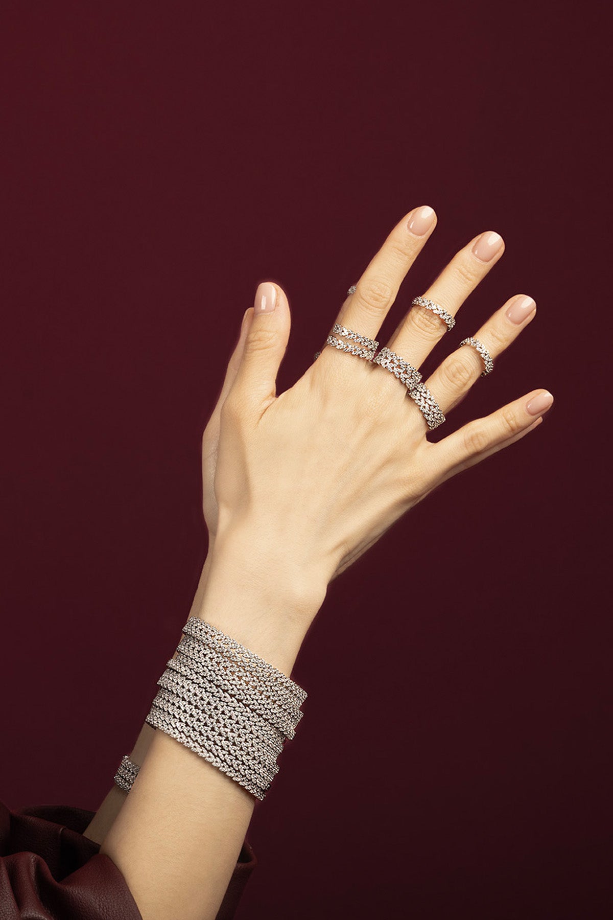 Woman wearing APM Monaco bracelets and rings, layered sparkle for a bold evening allure.