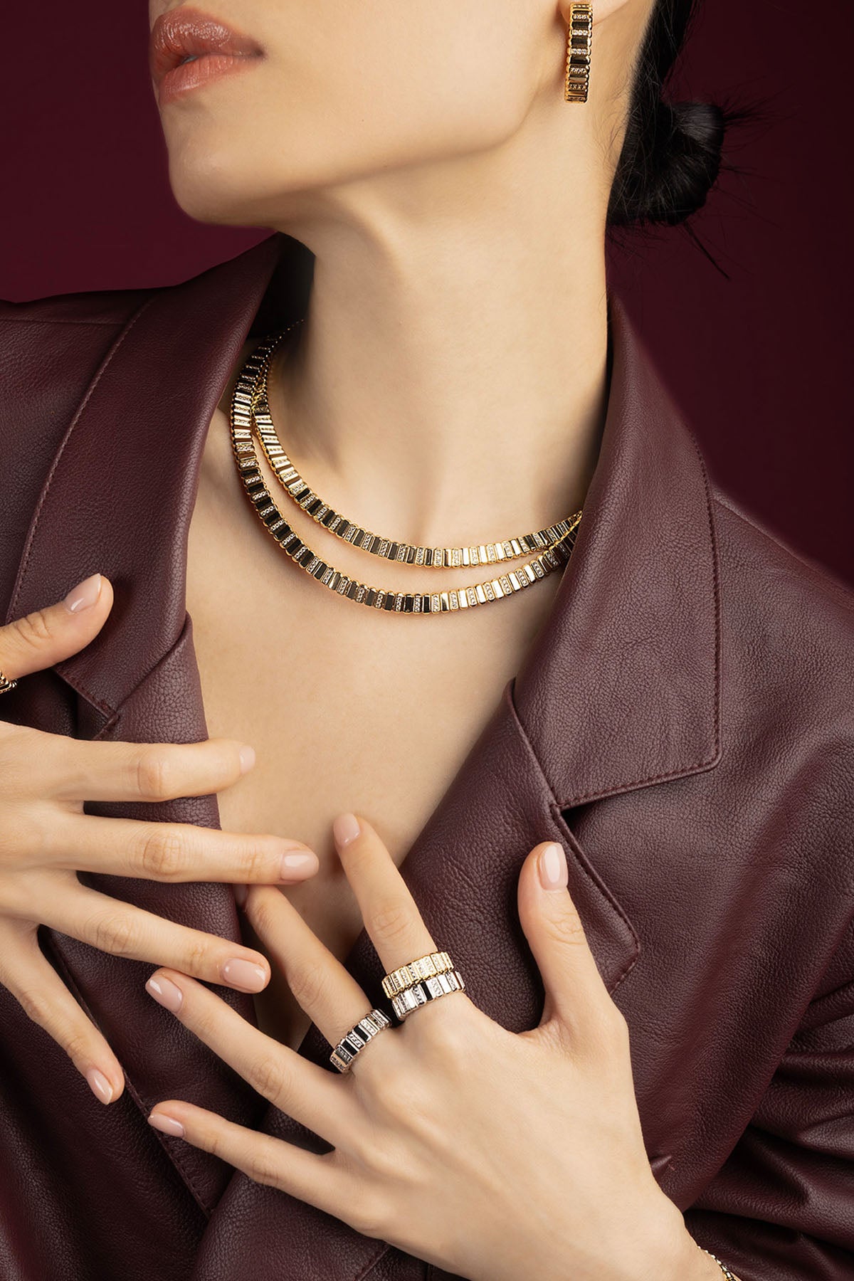 Woman wearing APM Monaco layered set, golden allure meets modern sophistication.