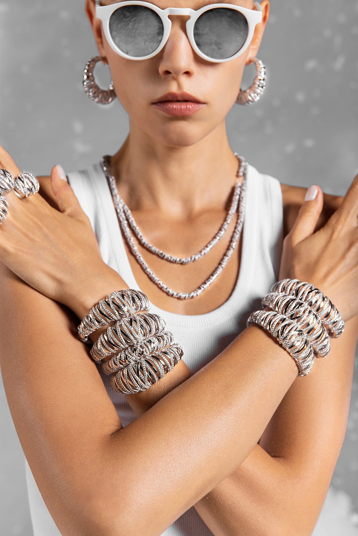 APM MONACO enlace bracelet in silver on a wrist with a white background