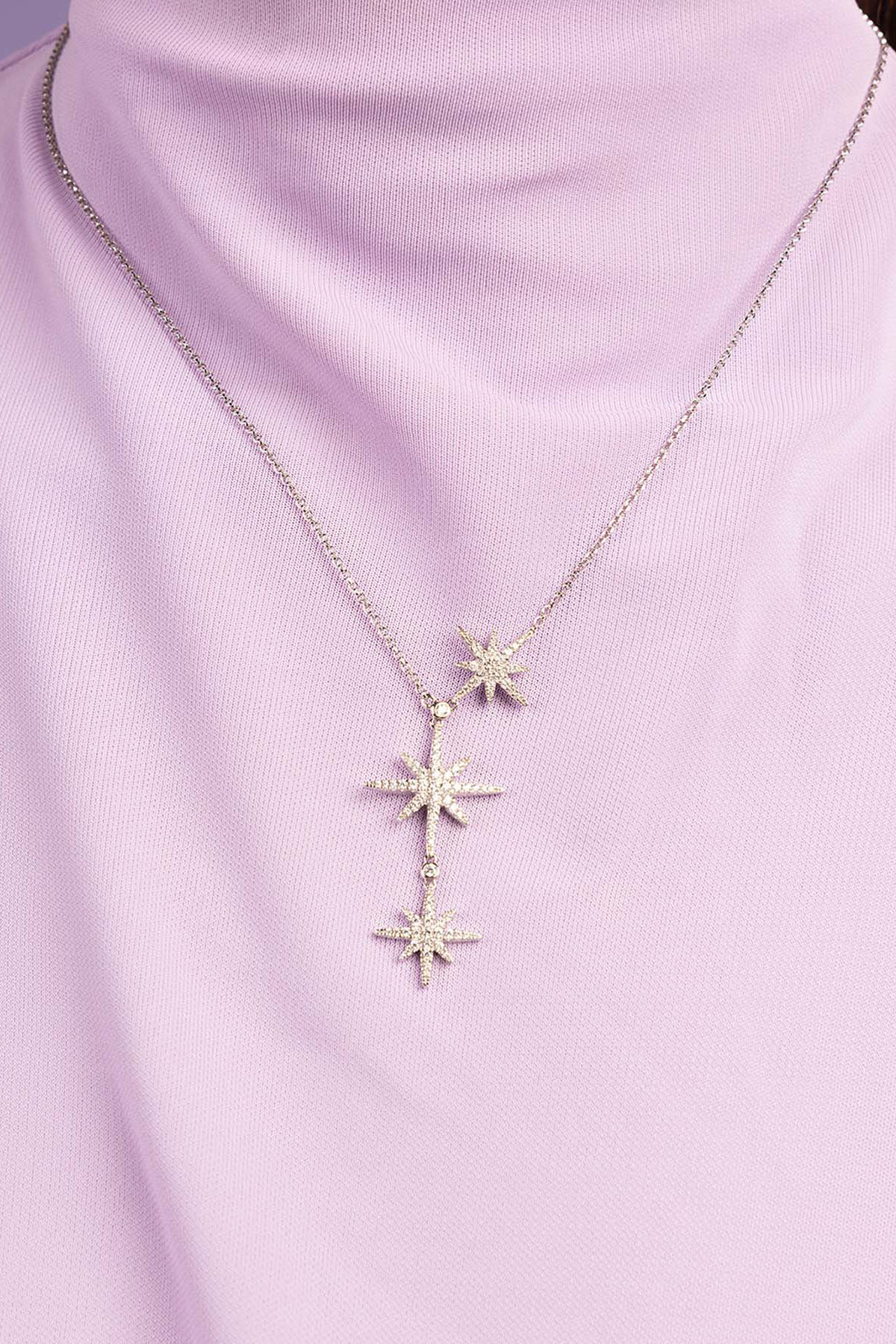 Necklace with star-shaped pendants on a light purple background