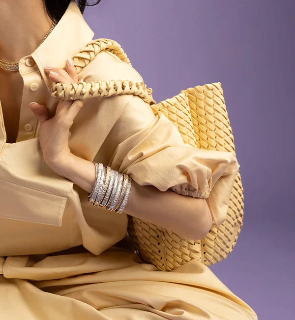 Person holding a yellow APM MONACO handbag with a plain background