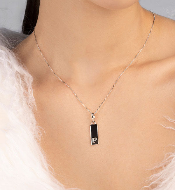 APM MONACO necklace with a pendant featuring a letter 'P' on a neutral background