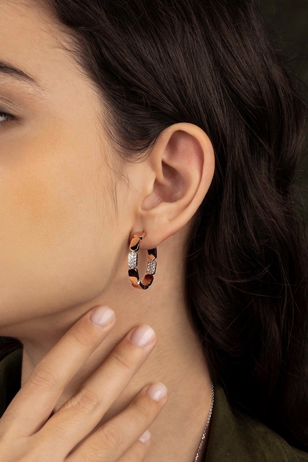Close-up of a person wearing a hoop earring with a blurred background
