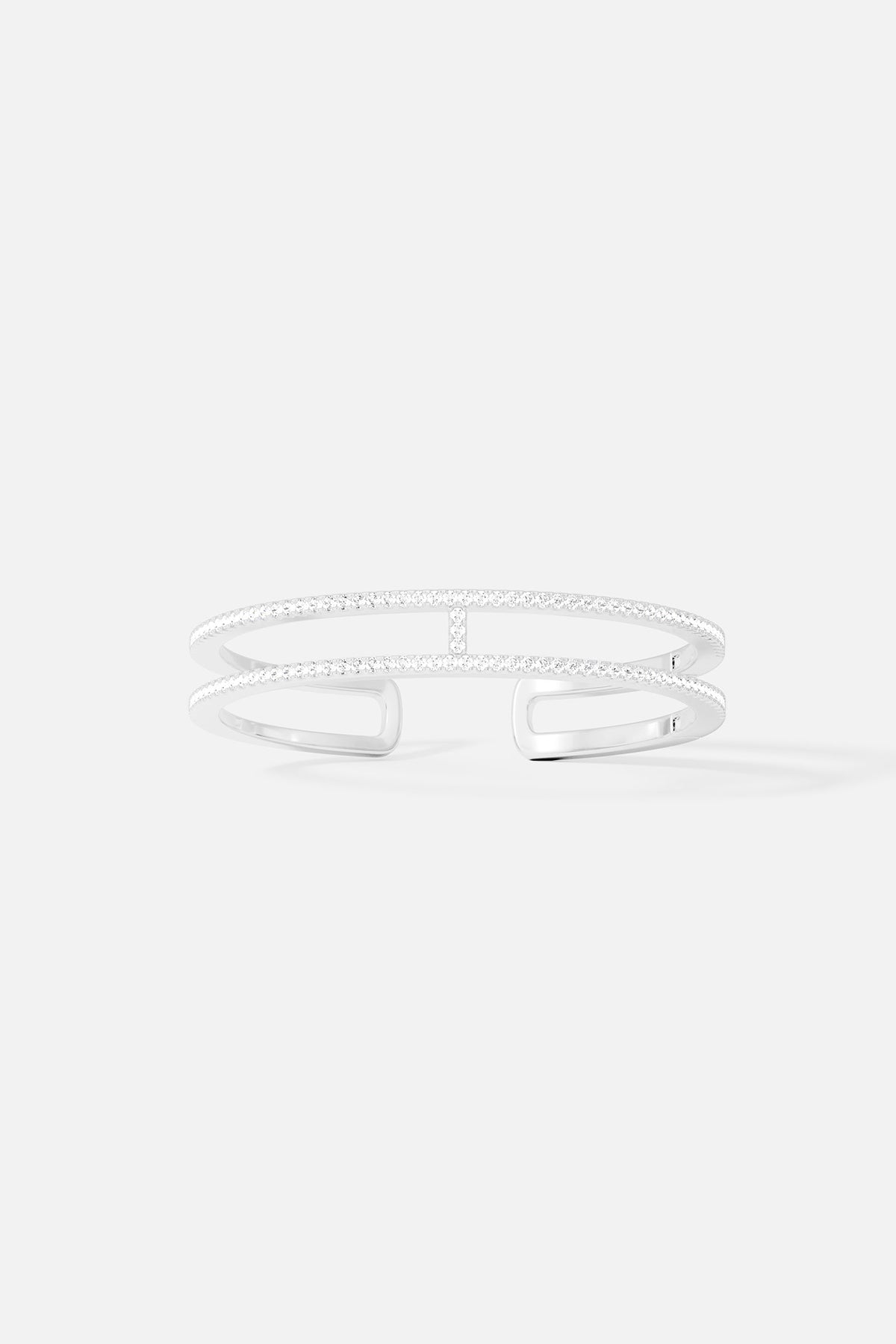 Bracelets APM Monaco, double-line pavé cuff bangle in white/silver tone with multiple rows of cubic zirconia.