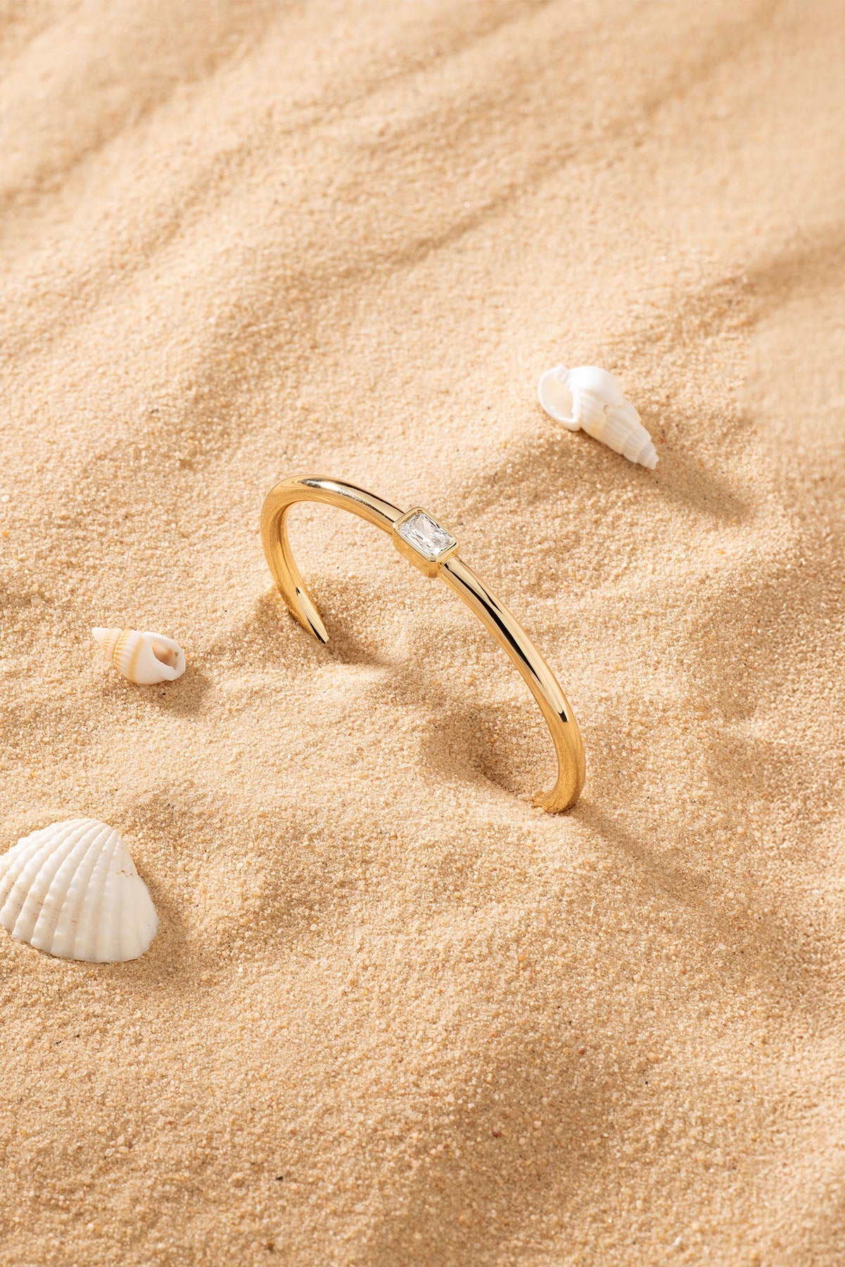 Bracelets APM Monaco cuff in yellow gold-tone, featuring a square-cut gemstone.