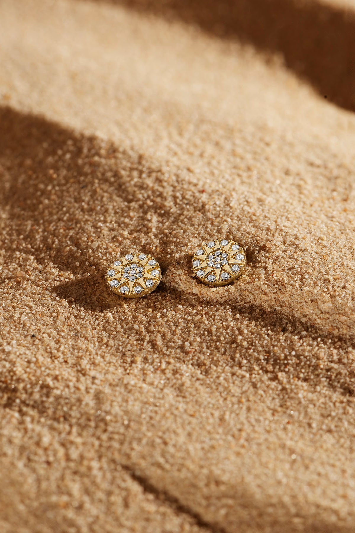 Earrings APM Monaco: two round yellow gold stud earrings with white diamonds.
